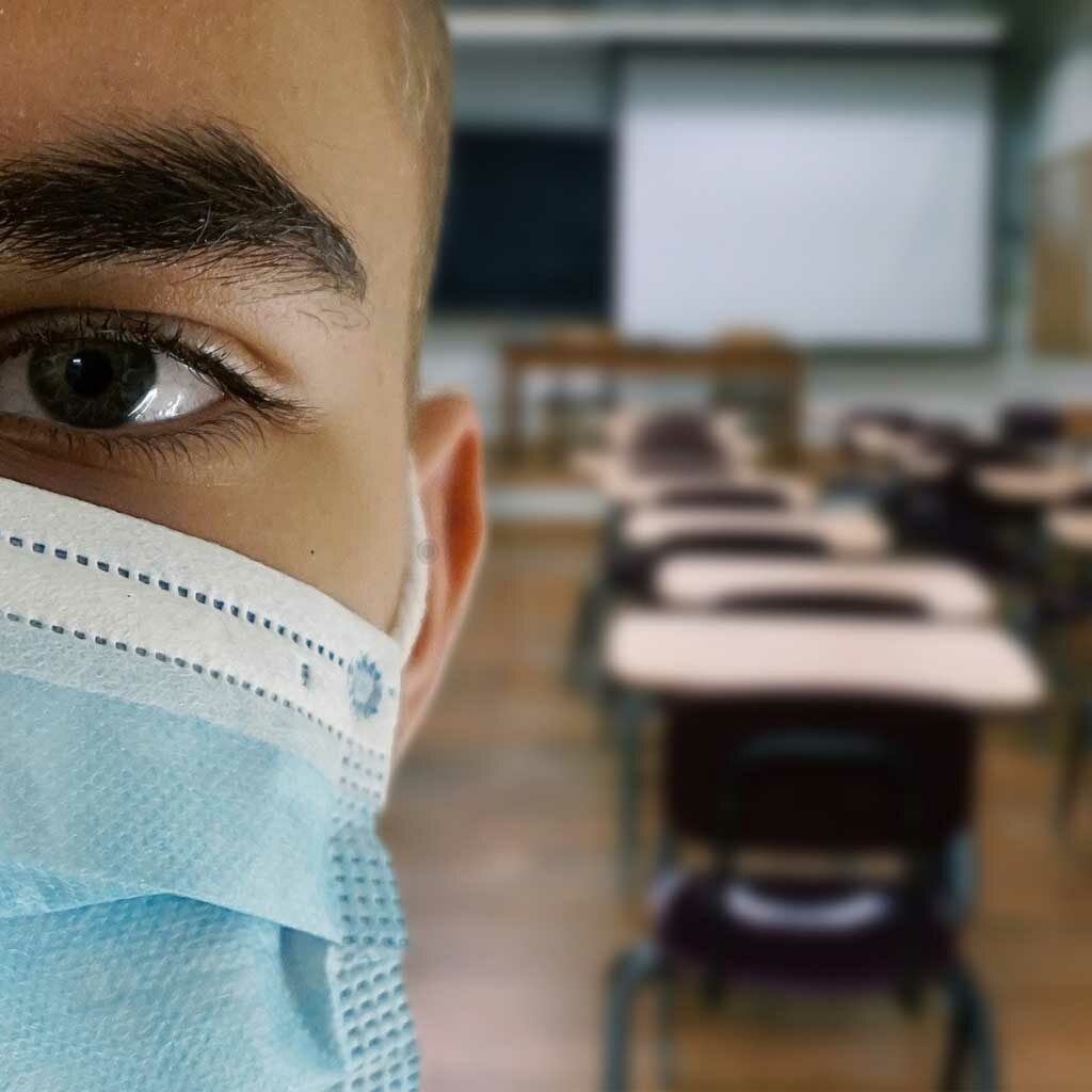 ragazzo che indossa mascherina protettiva in classe